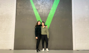 Two female athletes posing in front of the Invictus V.