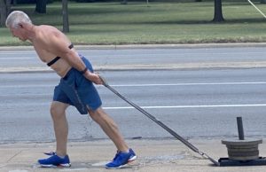 Invictus Masters Athlete, John Mariotti, drags a lead down his street.