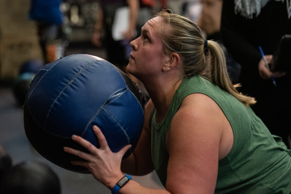 Female athlete at the bottom of a wall ball shot.