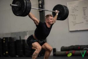 Invictus Athlete doing a heavy overhead squat.