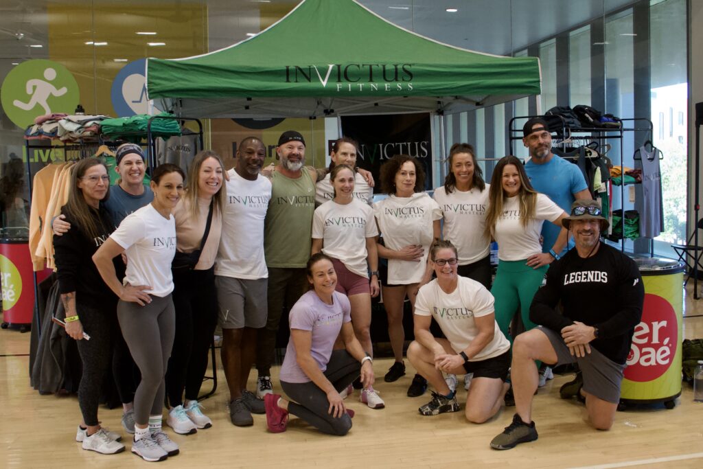 Invictus Masters athletes gathered in front of the Invictus booth at the Legends championship.