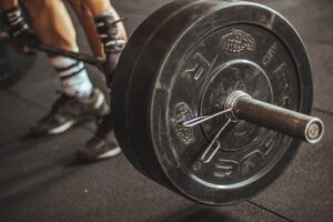 Person grabbing a barbell about to hook grip