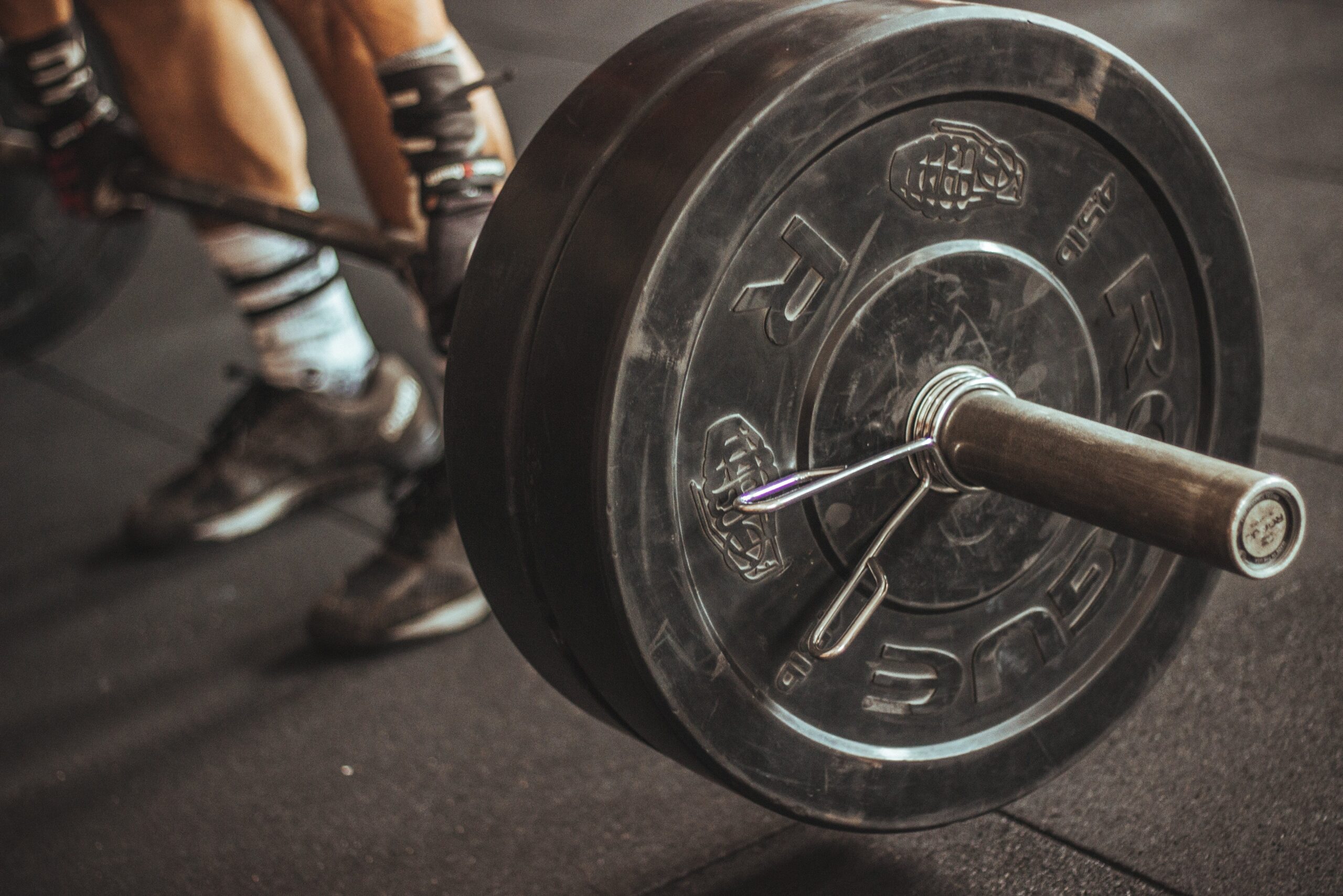 Person grabbing a barbell about to hook grip 