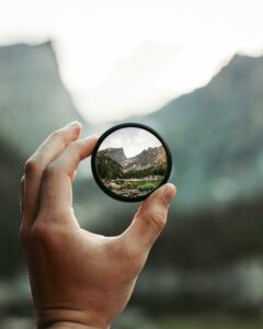 Someone looking at a mountain through an eye glass and just being curious!