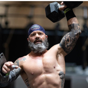 Masters Athlete doing a DB snatch during a workout